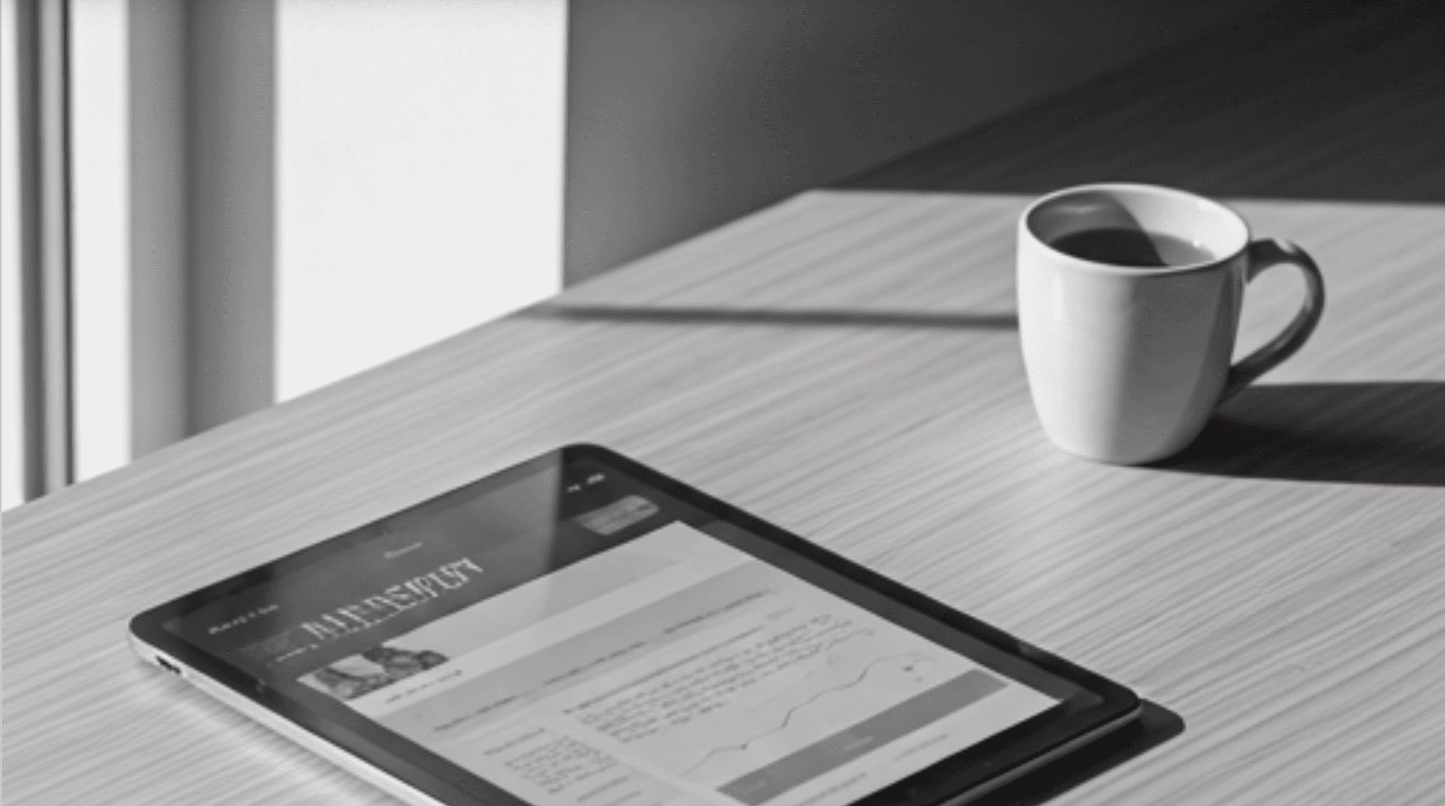 A tablet displaying a news app on a desk with a coffee cup
